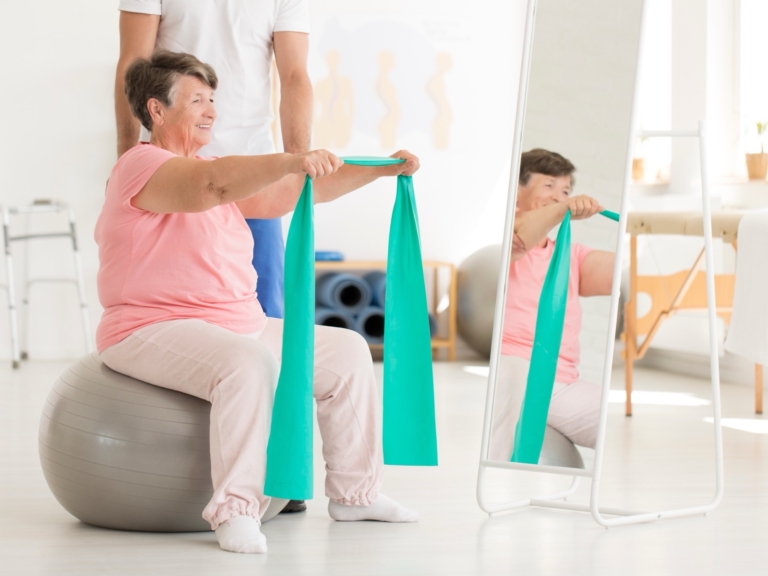 Older woman doing a shoulder exercise with a resistance band