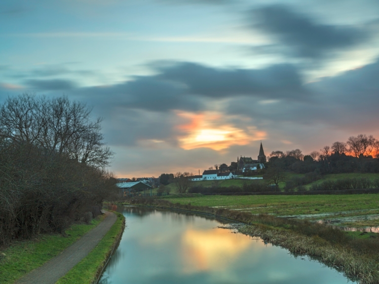 The Erewash Canal at dusk, with a church spire in the distance